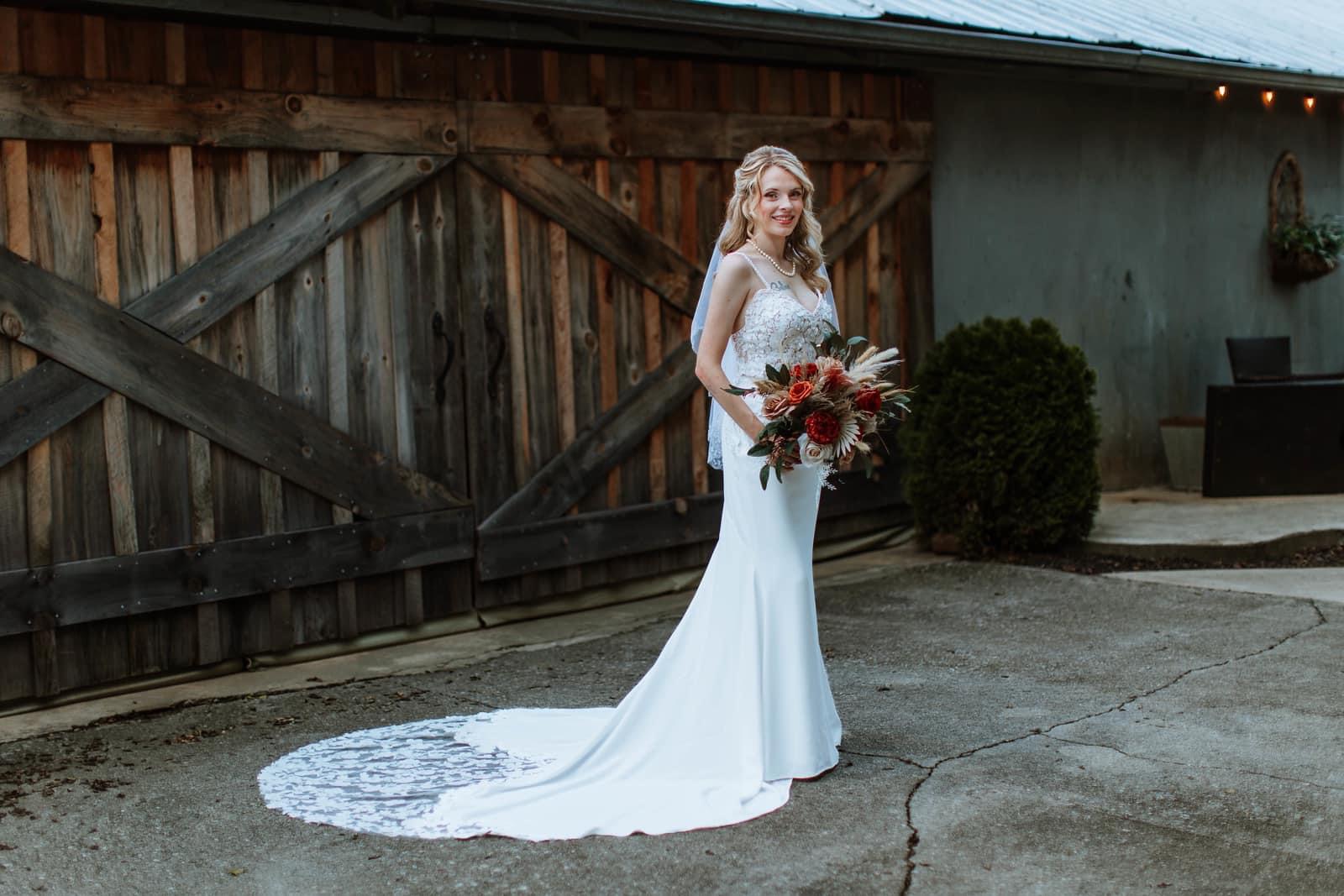Bride at rustic barn doors with bouquet