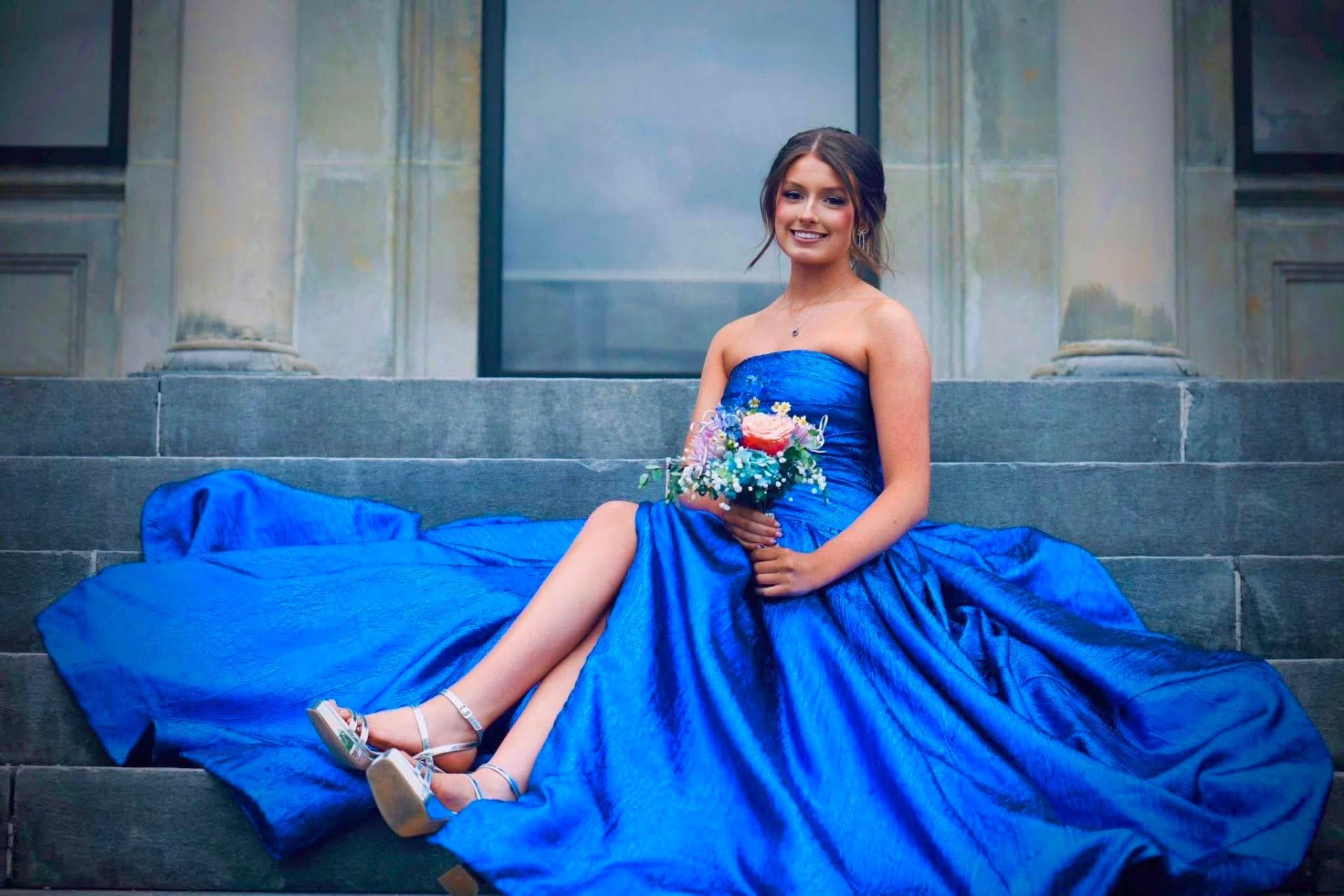 Royal blue strapless ballgown on stone steps